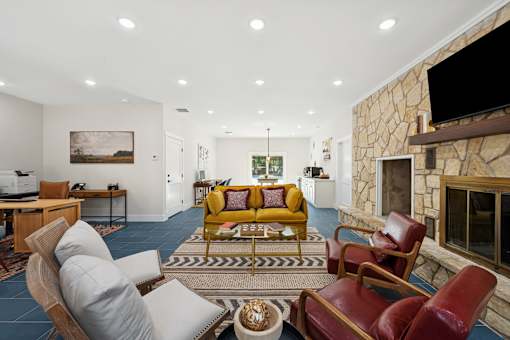 living room with a stone fireplace at Crosspoint Oaks at Boerne, Texas, 78006