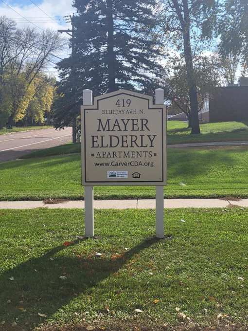 a sign in the grass in front of a cemetery