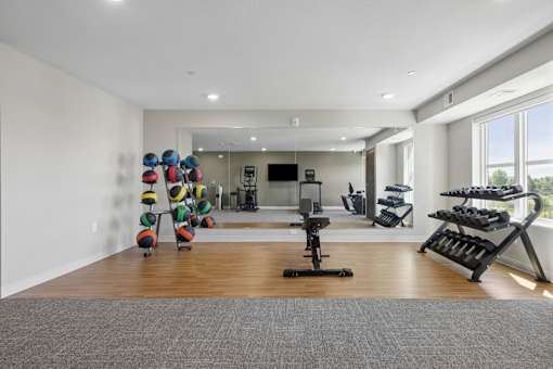A room with a variety of exercise equipment including a rowing machine, a stationary bike, and a treadmill.