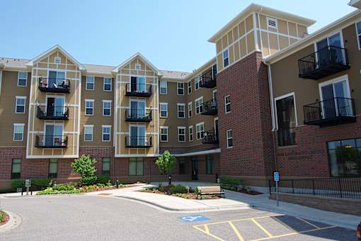 Apartment complex with a parking lot in front.