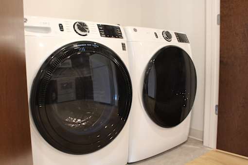 A front load washing machine and dryer in a closet.