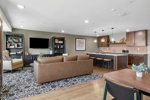 A modern living room with a brown sofa and a wooden dining table.