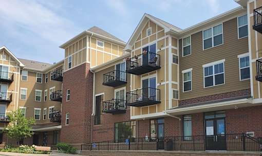 Apartment complex with balconies and a clear sky.