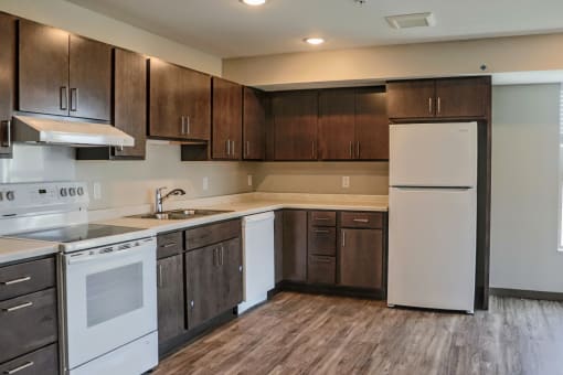 a kitchen with white appliances and dark wood cabinets