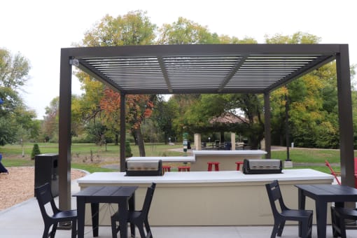 a patio with a bar and tables under awning