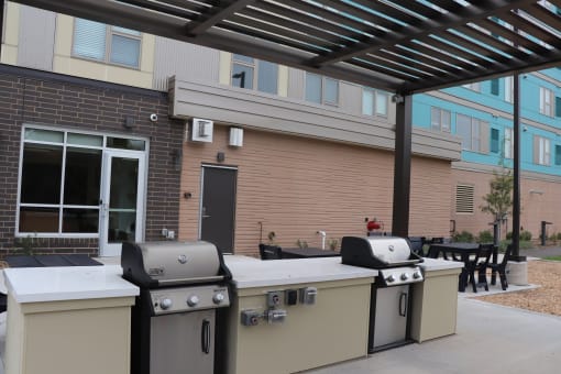 three bbq pits in front of a building