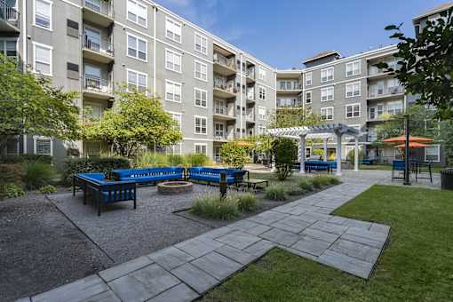 A sunny day at a residential complex with a playground and picnic tables.
