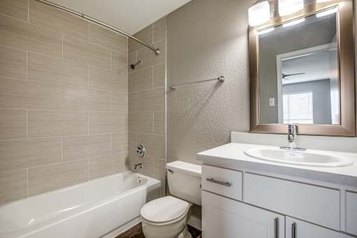 A bathroom with a white tub, toilet, and sink.
