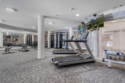 A spacious gym with treadmills, elliptical machines, and other exercise equipment.