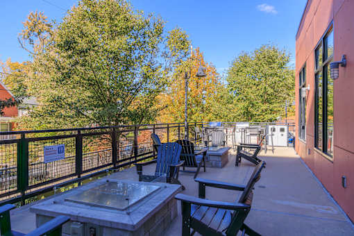 A patio with a table and chairs is surrounded by trees.
