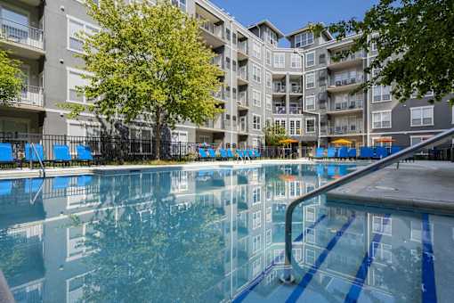 A large pool in front of apartment buildings.