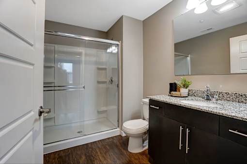 A bathroom with a toilet, sink, and shower.