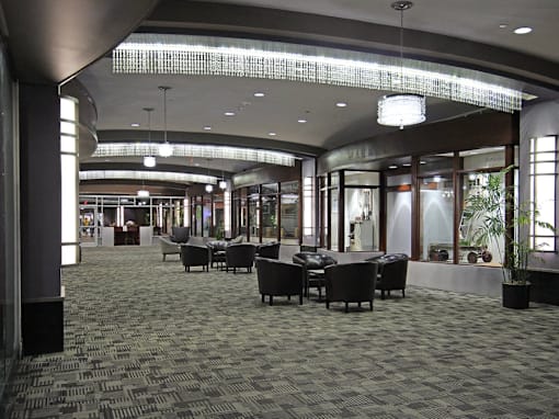A large room with a carpeted floor and a long table with chairs.