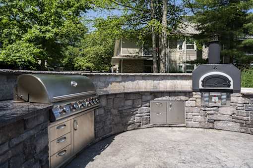 A stainless steel outdoor kitchen with a grill and oven.
