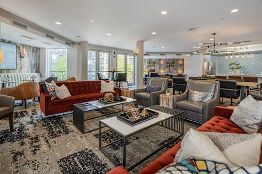 A living room with a red sofa and a glass coffee table.
