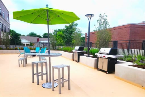 a patio with a table and chairs and a green umbrella
