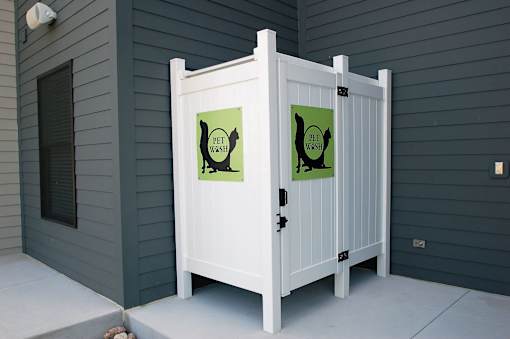 A white gate with two signs on it that say pet waste.