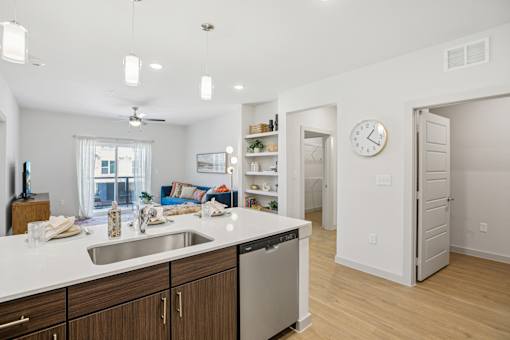 A kitchen with a white counter top and wooden cabinets. at ThreeTwenty at the Vybe Apartments, Texas, 78640