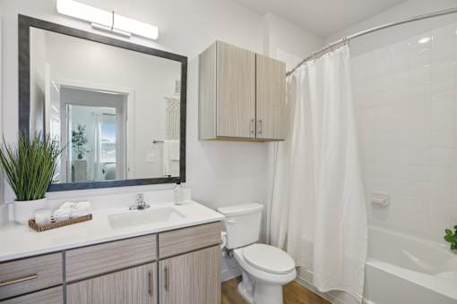 A white bathroom with a toilet, sink, and bathtub. at Park South Apartments, Austin