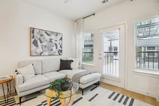 Bright living room with white sofa and patio access at Matador Apartments, Texas, 78745