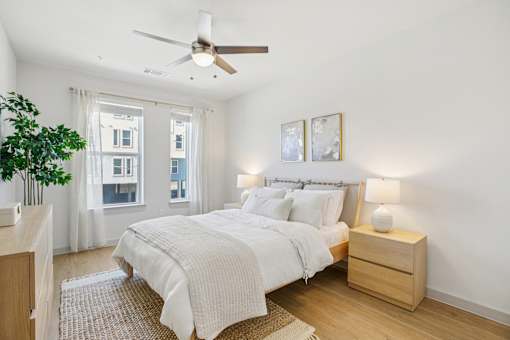 A bedroom with a large bed and a ceiling fan. at ThreeTwenty at the Vybe Apartments, Kyle, Texas