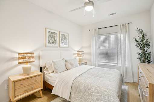Cozy bedroom with natural wood furnishings at Matador Apartments, Austin, Texas