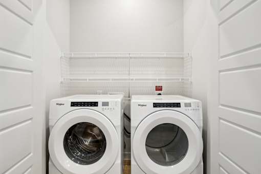 Two white washing machines in a laundry room. at Park South Apartments, Austin