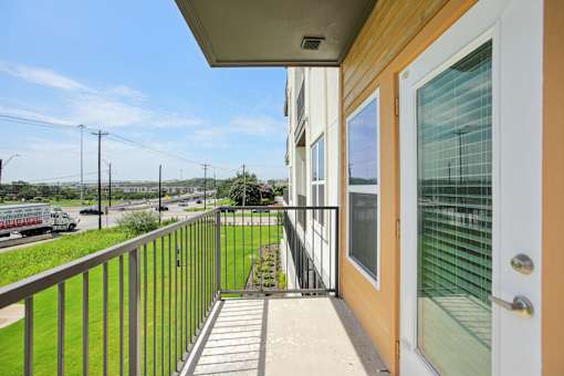 A balcony with a view of the street and a truck. at Park South Apartments, Texas, 78748