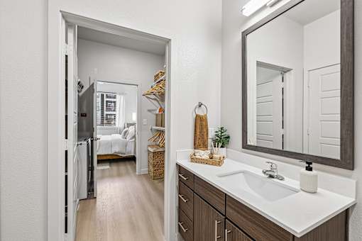 A bathroom with a white sink and a mirror.