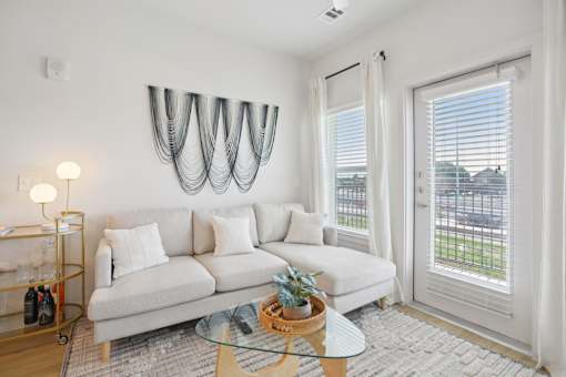 A white couch with a glass table in front of it. at Park South Apartments, Austin