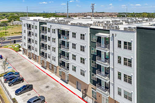 A large white building with a red line in the parking lot.