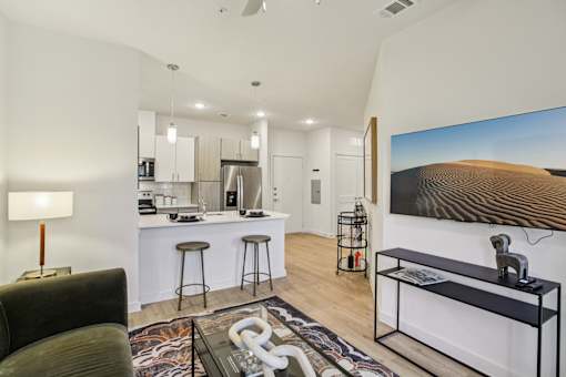 Open living room with kitchen island and bar stools at Matador Apartments, Austin