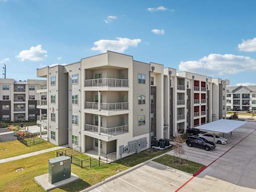Modern four story apartment building exterior at Cantarra Apartments, Manor, 78653