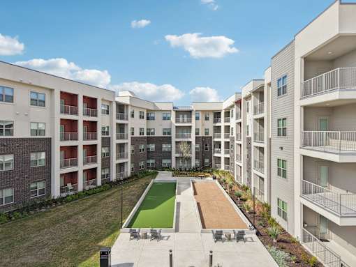 Central courtyard with bocce court and lawn at Cantarra Apartments, Manor, Texas