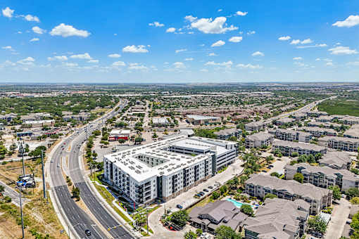 A large building with a lot of windows is surrounded by other buildings and houses.