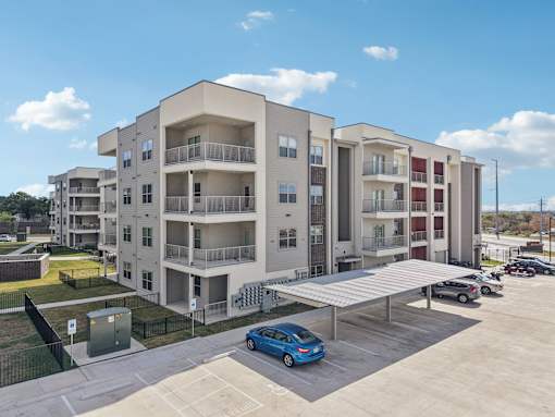 Modern apartment building with covered parking at Cantarra Apartments, Manor