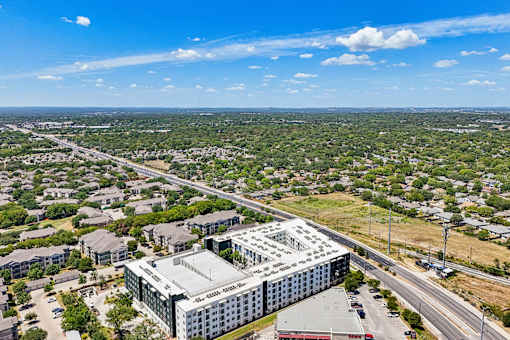 A large building with the words "ALLIANCE HOSPITAL" on it is surrounded by a parking lot and other buildings.