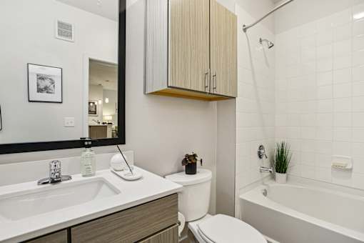 Bathroom with overhead cabinet and tiled shower at Matador Apartments, Austin, 78745