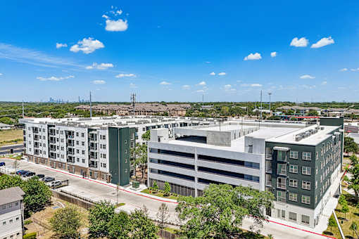A large building complex with a parking garage in front.