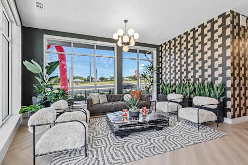 A living room with a black and white patterned wall and a large window.