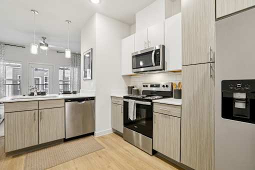 Kitchen with wood grain cabinetry and stainless appliances at Matador Apartments, Austin