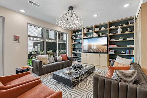 A modern living room with a large couch, a coffee table, and a bookshelf.