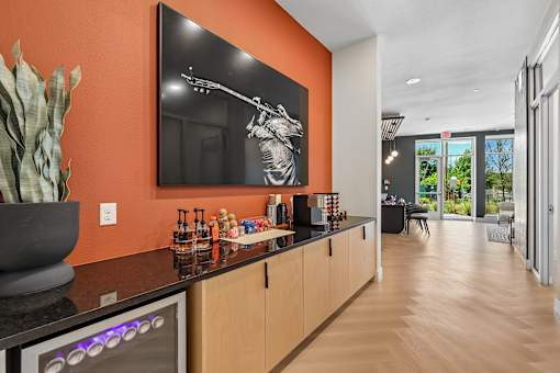 A modern kitchen with a bar area and a painting of a man holding a gun.