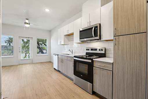 Open concept kitchen with wood tone cabinets at Matador Apartments, Austin