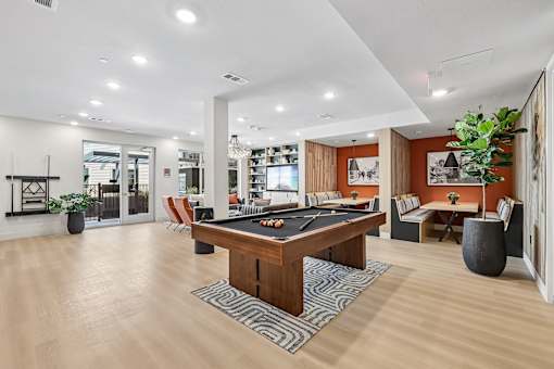 A room with a pool table and a sofa.