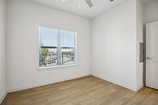 Empty bedroom with window and ceiling fan 1 at Matador Apartments, Austin, TX 78745
