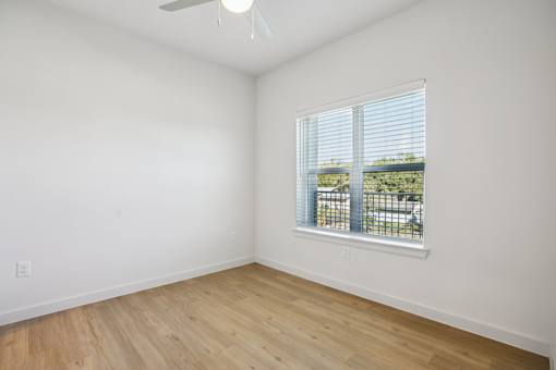Empty bedroom with ceiling fan and window blinds at Matador Apartments, Austin, 78745