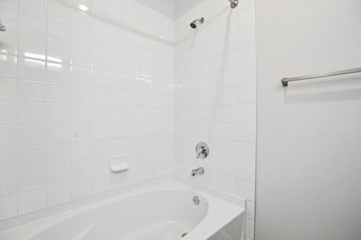 White tiled bathroom with tub and shower combo at Matador Apartments, Austin, Texas