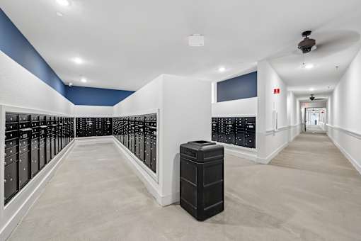 A long hallway with a black trash can in the middle.