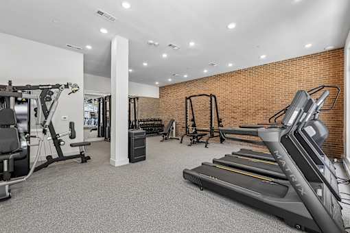 A gym with treadmills, weights, and other exercise equipment.